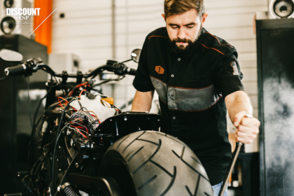 Repair man fixes motorcycle for customer with extended service plan