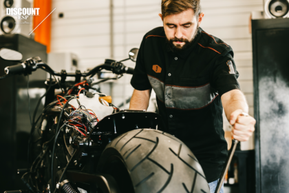 Repair man fixes motorcycle for customer with extended service plan Repair man fixes motorcycle for customer with extended service plan