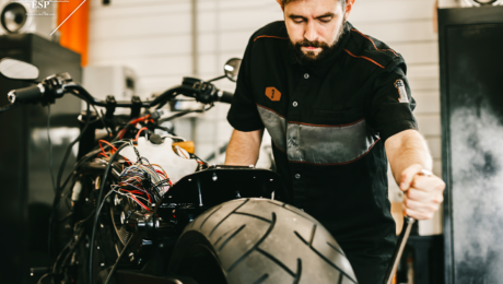Repair man fixes motorcycle for customer with extended service plan
