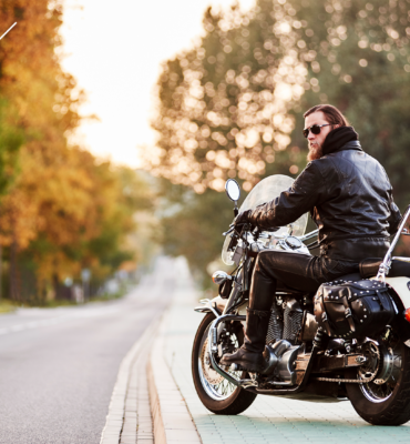 Man on a motorcycle parked on the side of the road